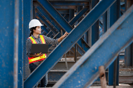construction engineer Asian female architect with tablet computer at expressway construction site young woman watching expressway construction siteの写真素材