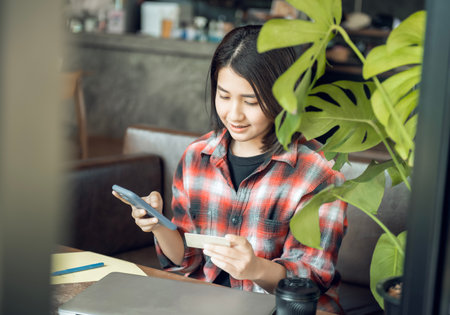 Asian woman holding plastic credit card and using laptop Online shopping concept. Tone image.の写真素材