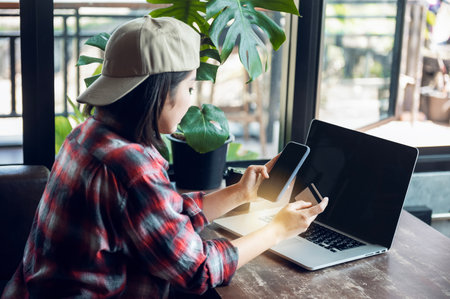 Asian woman holding plastic credit card and using laptop Online shopping concept. Tone image.の写真素材