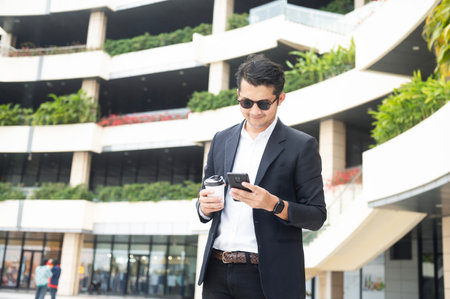 Asian young businessman Searching for information on internet with smartphone. Business, education, lifestyle concept.の写真素材