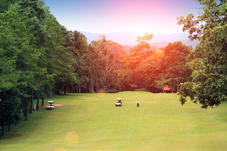 Golfers are playing golf along green golf in Thailandのeditorial素材