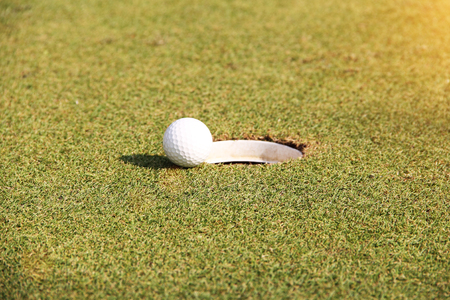 Blurred golf ball on green in the evening golf course with sunshine in thailandの写真素材