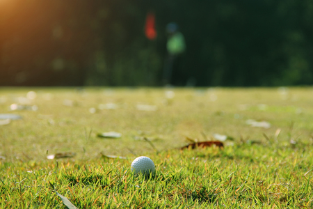 Blurred golf ball on green in the evening golf course with sunshine in thailandの写真素材