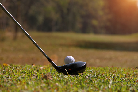 Blurred golf club and golf ball close up in grass field with sunset. Golf ball close up in golf coures at Thailandの写真素材