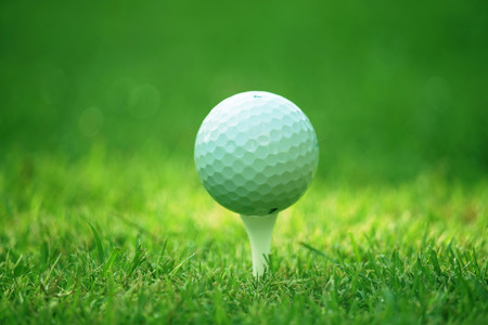 Golf ball on tee in the evening golf course with sunshine in thailandの写真素材