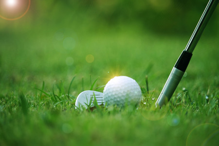 golf club and golf ball close up in grass field with sunset. Golf ball close up in golf coures at Thailandの写真素材