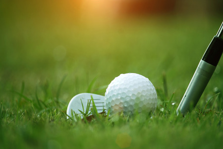 golf club and golf ball close up in grass field with sunset. Golf ball close up in golf coures at Thailandの写真素材