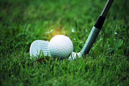 golf club and golf ball close up in grass field with sunset. Golf ball close up in golf coures at Thailandの写真素材