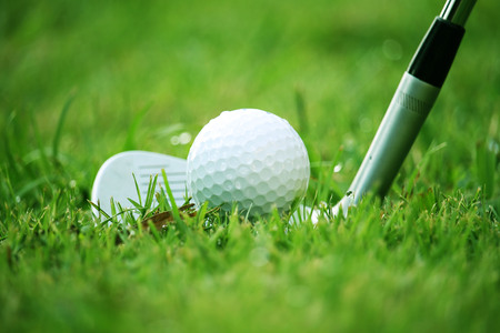 golf club and golf ball close up in grass field with sunset. Golf ball close up in golf coures at Thailandの写真素材