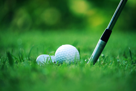 golf club and golf ball close up in grass field with sunset. Golf ball close up in golf coures at Thailandの写真素材