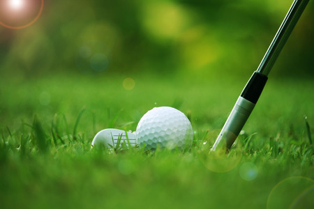 golf club and golf ball close up in grass field with sunset. Golf ball close up in golf coures at Thailandの写真素材