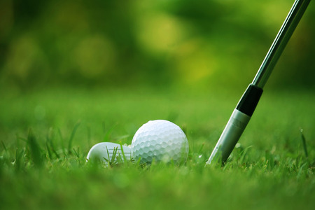 golf club and golf ball close up in grass field with sunset. Golf ball close up in golf coures at Thailandの写真素材