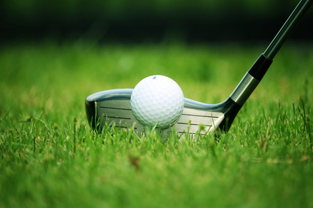 golf club and golf ball close up in grass field with sunset. Golf ball close up in golf coures at Thailandの写真素材