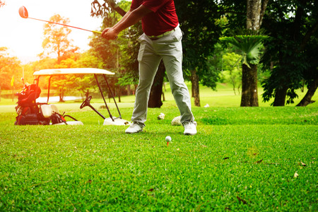 Golfer playing golf beside the golfcar in beautiful golf course in the evening golf course with sunshine in thailandの写真素材