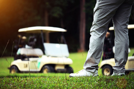 Golfer and golfcar in beautiful golf course in the evening golf course with sunshine in thailandの写真素材