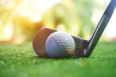 Golf ball and golf club in beautiful golf course at sunset background.の写真素材