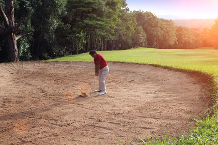 Blurred golfer playing golf in beautiful golf course in the evening golf course with sunshine in...
