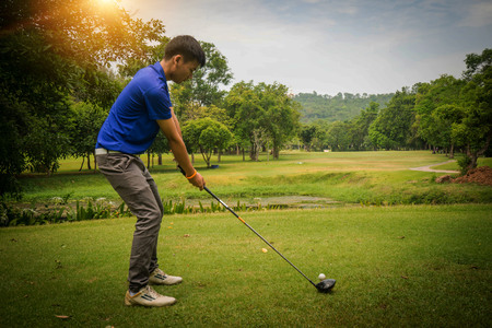 Golfer playing golf in the evening golf course, on sun set evening time. Man playing golf on a golf course in the sun.の写真素材