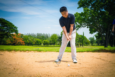 Blurred golfer playing golf in the evening golf course, on sun set evening time. Man playing golf on a golf course in the sun.の写真素材