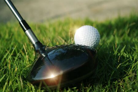 Golf club and golf ball on green grass in the evening golf course with sunshine in thailandの写真素材