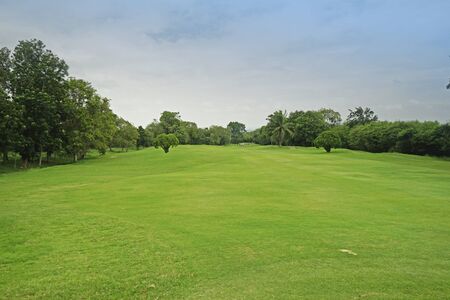 Background evening golf course has sunlight shining down at golf course in Thailandの写真素材