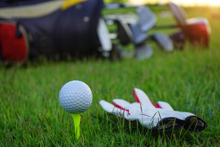 Golf ball on tee ready to be shot. golf ball on tee in the evening golf course with sunshine.                               の写真素材