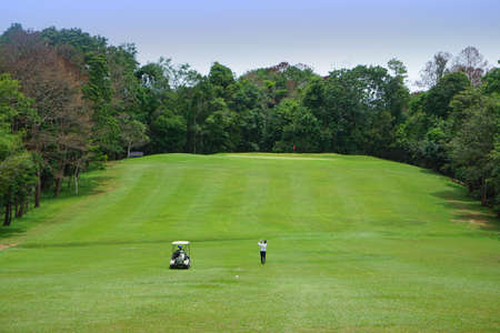 Blurred golfer playing golf in beautiful golf course in the evening golf course with sunshine in thailand.の写真素材