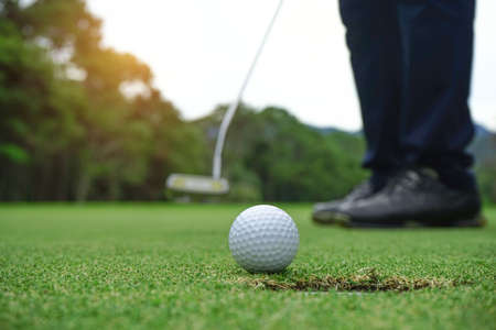 Blurred golfer playing golf in beautiful golf course in the evening golf course with sunshine in thailand.の写真素材
