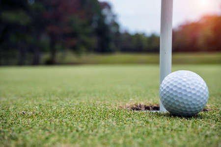 Blurred golfer playing golf in beautiful golf course in the evening golf course with sunshine in thailand.の写真素材