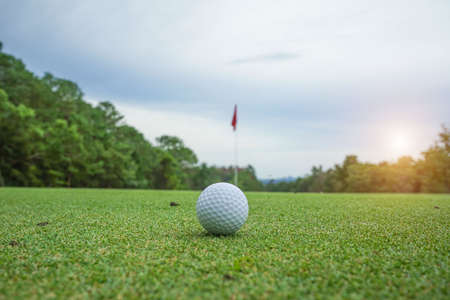 Blurred golf ball on green in the evening golf course with sunshine in thailand.の写真素材