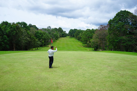Blurred golfer playing golf in the evening golf course, on sun set evening time. Man playing golf on a golf course in the sun.の写真素材