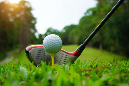Golf ball and golf club in beautiful golf course at Thailand. Collection of golf equipment resting on green grass with green background.の写真素材