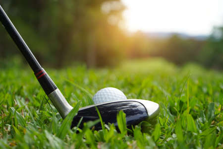 Golf ball and golf club in beautiful golf course at Thailand. Collection of golf equipment resting on green grass with green background.の写真素材