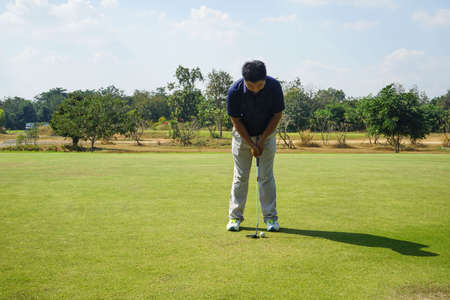 Golfer playing golf in the evening golf course, on sun set evening time. Man playing golf on a golf course in the sun.の写真素材