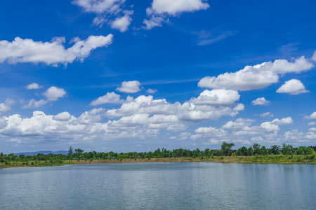 Green grass field on blue sky with cloud background. Green meadow under blue sky with clouds.の写真素材