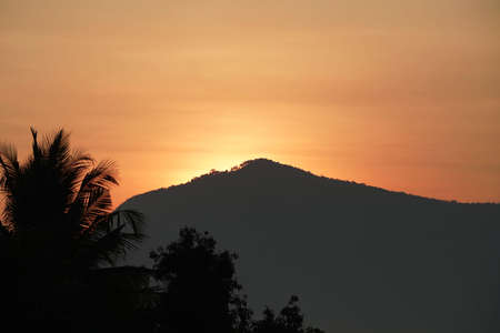 Golden morning sky in winter, misty high mountain background. Silhouette hills and misty in the morning at Chaiyaphum,Thailand.の写真素材