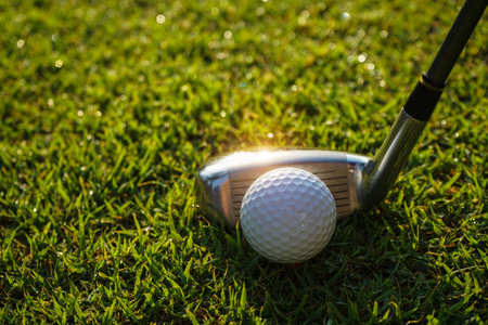 Golf club and ball in green grass. Golf balls on the golf course with golf clubs ready for golf in the first short. In the morning, with the beautiful sunlight.の写真素材