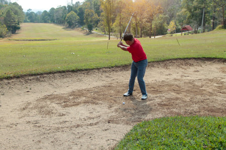 Blurred golfer playing golf in the evening golf course, on sun set evening time. Man playing golf on a golf course in the sun.の写真素材
