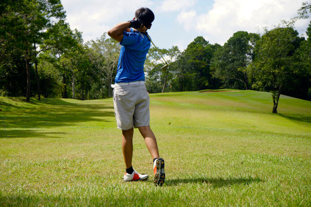 Golfer playing golf in the evening golf course, on sun set evening time. Man playing golf on a golf course in the sun.の写真素材