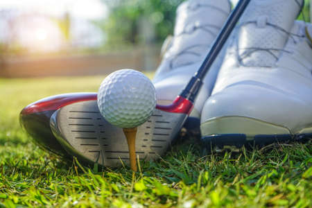 Golf club and golf ball close up in grass field with sunset. Golf ball close up in golf coures at Thailand.の写真素材