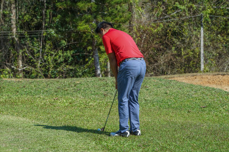 Golfer are playing game golf and hitting go on green grass mountain background. Asia male player game shot in summer. Sport holiday lifestyle concept.の写真素材