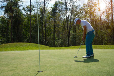 Golfer are playing game golf and hitting go on green grass mountain background. Asia male player game shot in summer. Sport holiday lifestyle concept.の写真素材