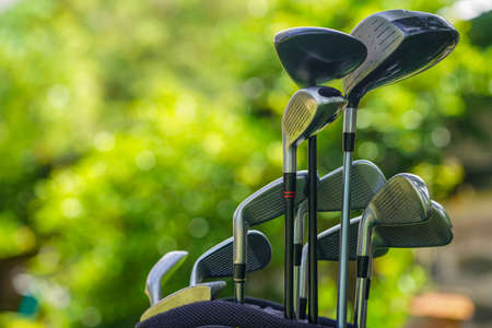 Golf equipment. Golf ball and golf club on green grass background. Collection of golf equipment resting on green grass. Outdoor sport.の写真素材