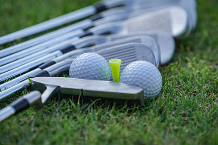 Golf equipment. Golf ball and golf club on green grass background. Collection of golf equipment resting on green grass. Outdoor sport.の写真素材