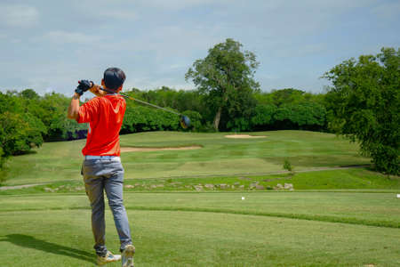 Golfer playing golf in the evening golf course, on sun set evening time. Man playing golf on a golf course in the sun.の写真素材