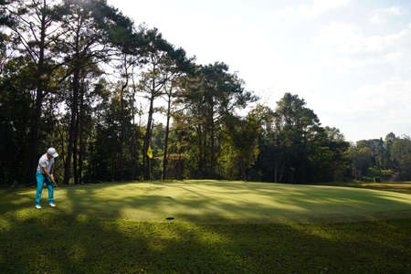 Wooden floor and golf course background. Fresh spring green golf course with wood floor. Beauty natural background, Empty wooden deck table with Green background.の写真素材