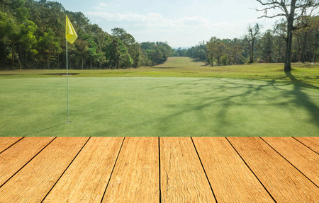 Wooden floor and golf course background. Fresh spring green golf course with wood floor. Beauty natural background, Empty wooden deck table with Green background.の写真素材