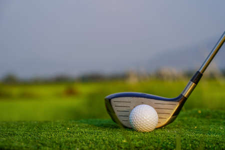 Golf clubs and golf balls on a green lawn in a beautiful golf course with morning sunshine. golf ball on green grass ready to hit on golf course background.の写真素材