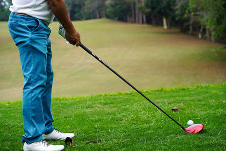 Golf clubs and golf balls on a green lawn in a beautiful golf course with morning sunshine. golf ball on green grass ready to hit on golf course background.の写真素材