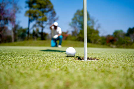 Golfer playing golf in the evening golf course, on sun set evening time. Man playing golf on a golf course in the sun.の写真素材
